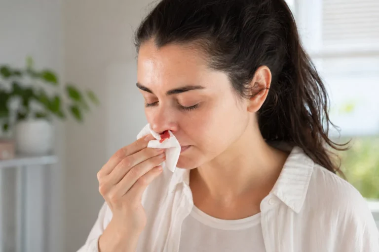 person managing a nosebleed at home